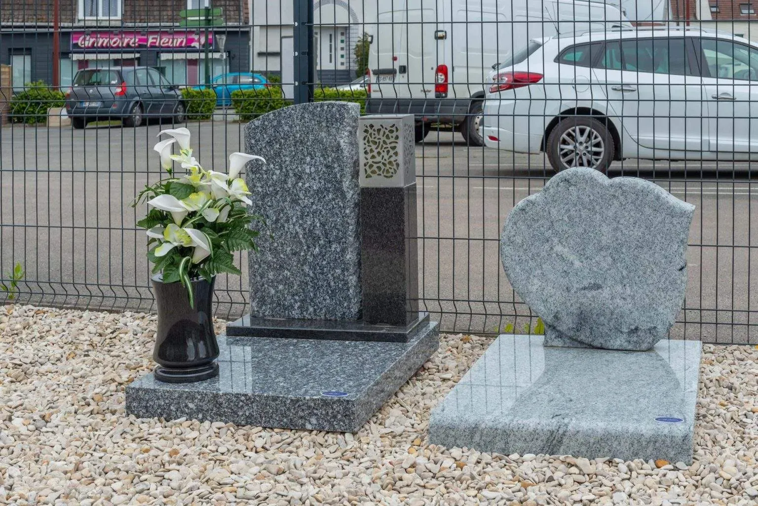 Deux monuments funéraires en granit gris avec vase de fleurs.