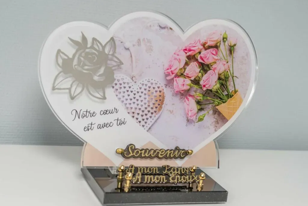 Plaque funéraire en forme de cœur avec messages d'affection et roses.